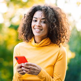 Female smiling holding a cell phone